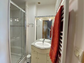 Chuveiro, secador de cabelo, toalhas de banho, papel higiênico