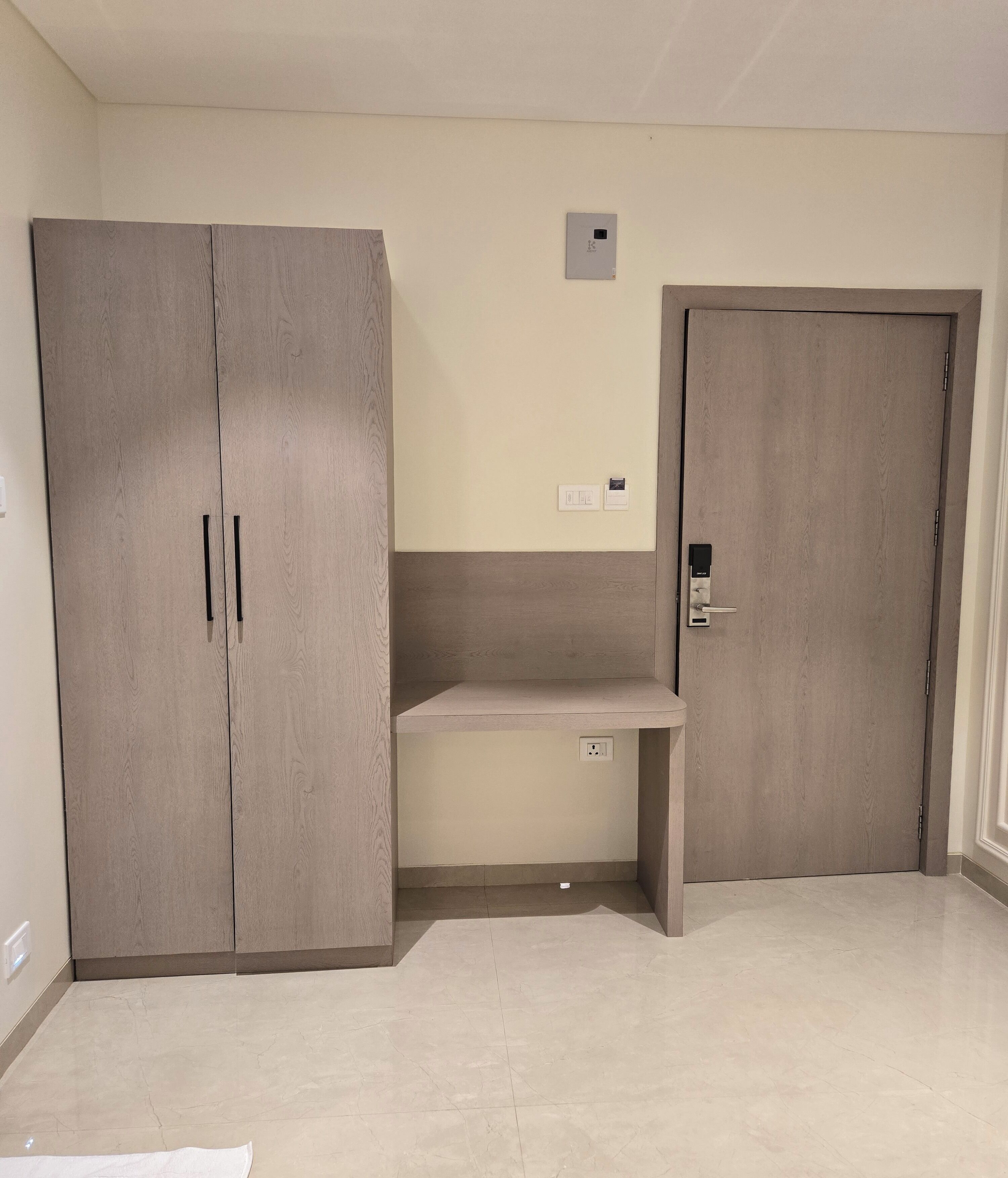 Una habitación con un armario grande, un escritorio y una puerta.