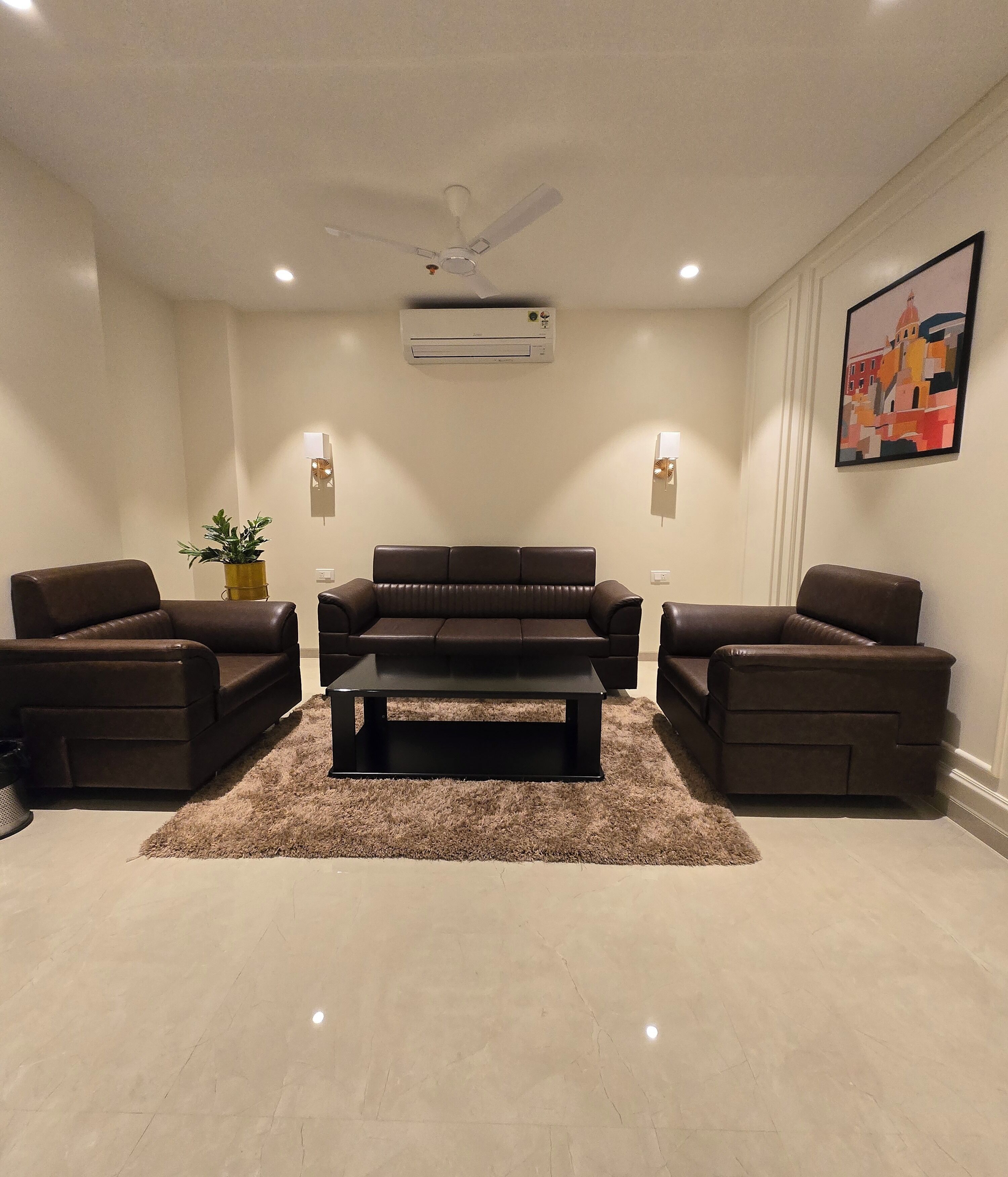 A living room with a sectional sofa, two armchairs, a coffee table, a ceiling fan, recessed lighting, an air conditioning unit, and a potted plant.