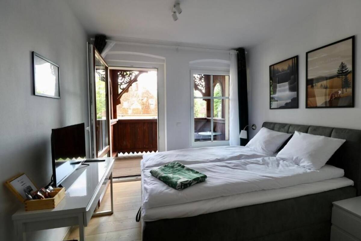 Un dormitorio con una cama, un escritorio y una ventana.