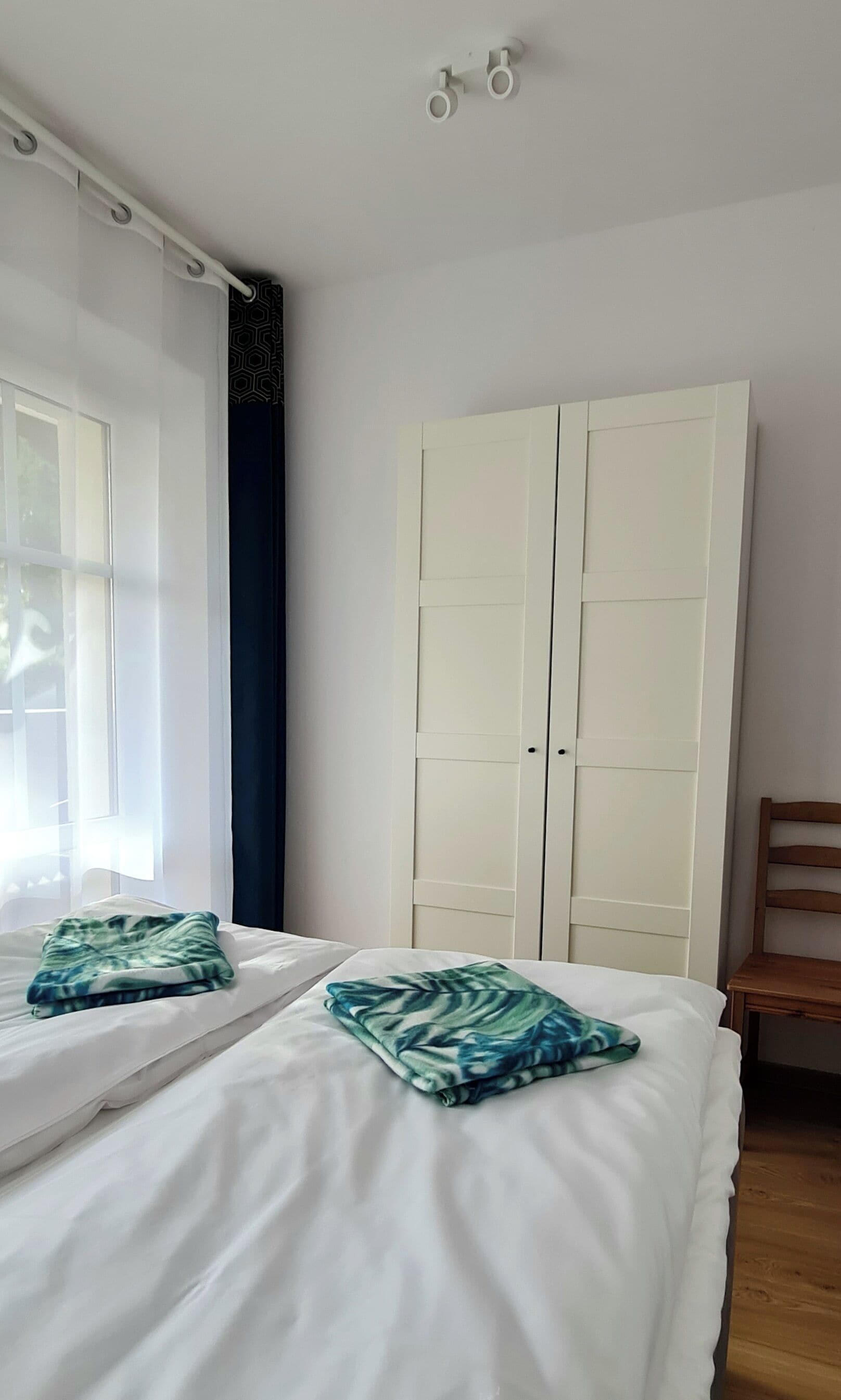 Ein Schlafzimmer mit einem Bett, einem Kleiderschrank und einem Sessel.