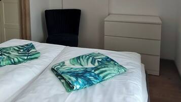 A hotel room with a bed, a chair, and a bedside table.