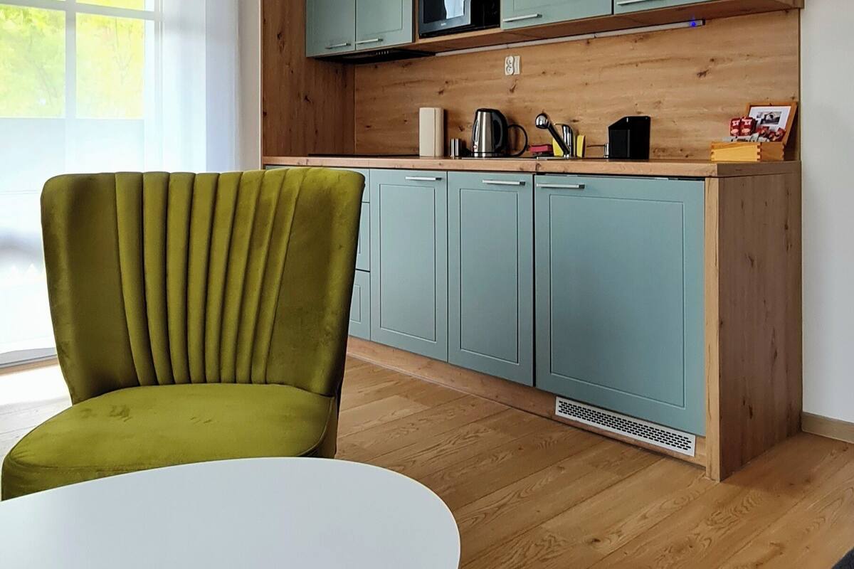 Una cocina moderna con gabinetes color turquesa, un microondas y una encimera de madera.