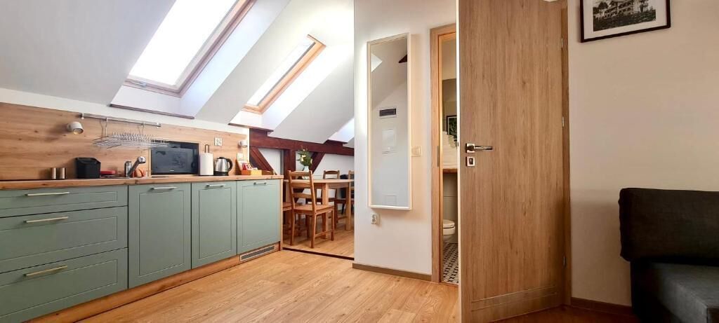 A compact kitchen with skylights, a dining area, and a visible bathroom door.