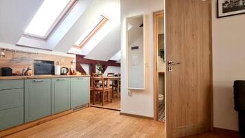 A compact kitchen with skylights, a dining area, and a visible bathroom door.