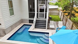 Un giardino con piscina, una veranda coperta e un recinto in legno.