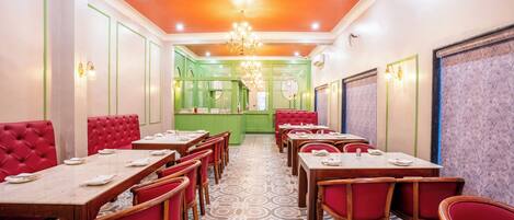 A restaurant with red upholstered booths, wooden tables, and patterned floor tiles.