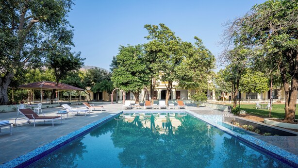 Ein Pool mit Liegestühlen und einer Laube.