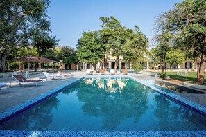 A swimming pool with lounge chairs and a gazebo. - juSTa Alwar Bagh Resort - Sariska (Alwar)