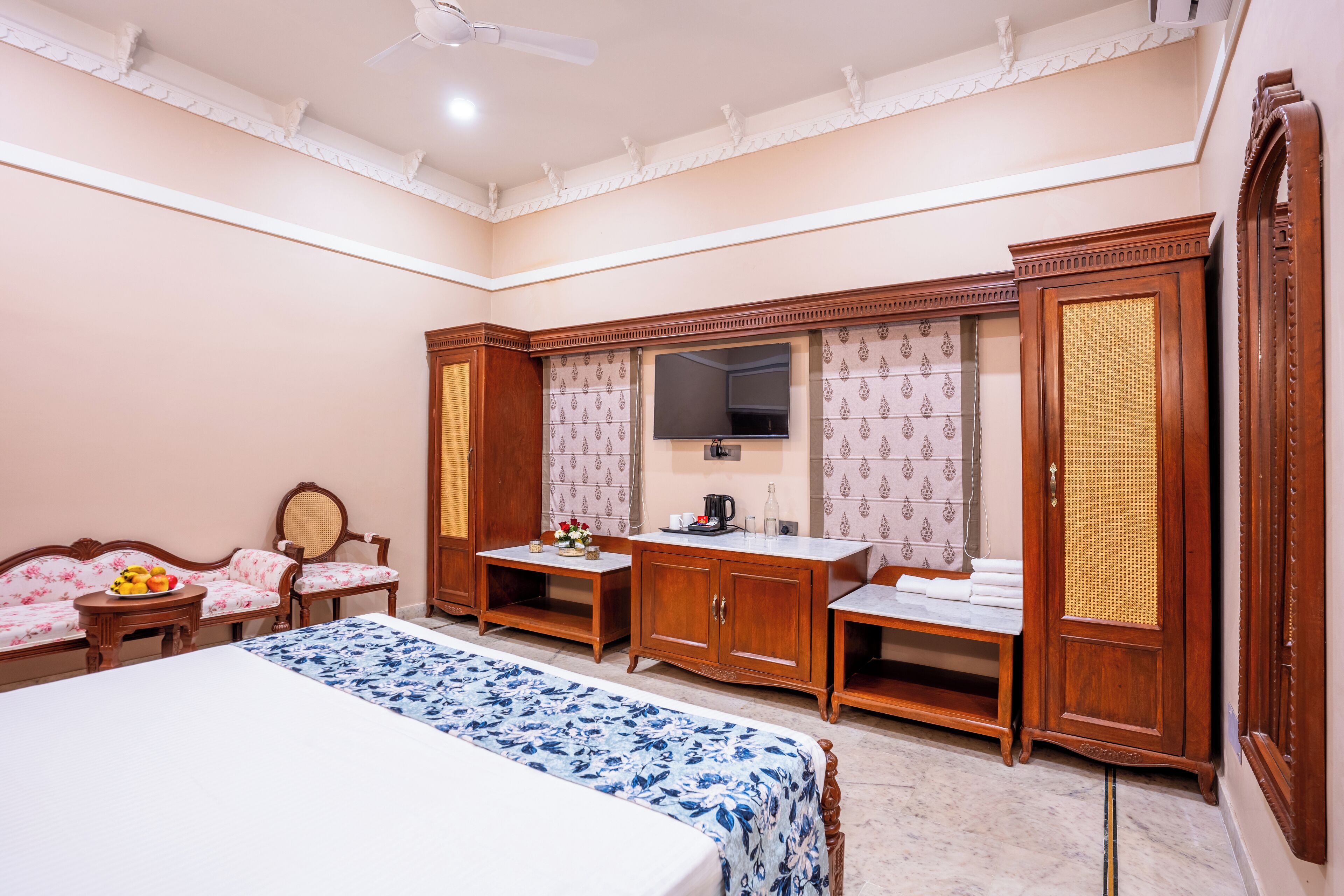 Une chambre d’hôtel équipée d’un lit, d’un bureau, d’une chaise, d’une armoire et d’un téléviseur.
