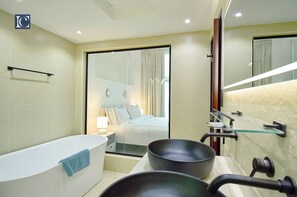 Een aparte badkuip en douche, handdoeken, zeep, shampoo