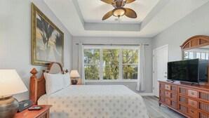 A bedroom with a bed, nightstands, a dresser, a television, and a ceiling fan. - Ironwood 1634 - Stunning Corner Unit! (North Myrtle Beach)