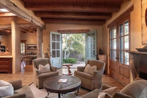 A cozy living room with a fireplace, a dining area, and a view of the outdoors.
