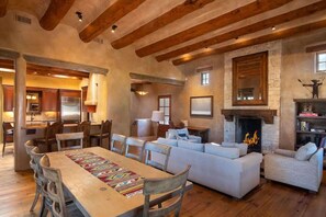 A spacious living area with a fireplace, a dining table with chairs, and a cozy seating arrangement.