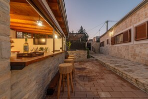 Relax on the patio with a drink, surrounded by a brick-patterned floor and comfortable seating.