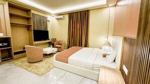 Una habitaci ón de hotel moderna con cama, escritorio, silla, televisión y armario.