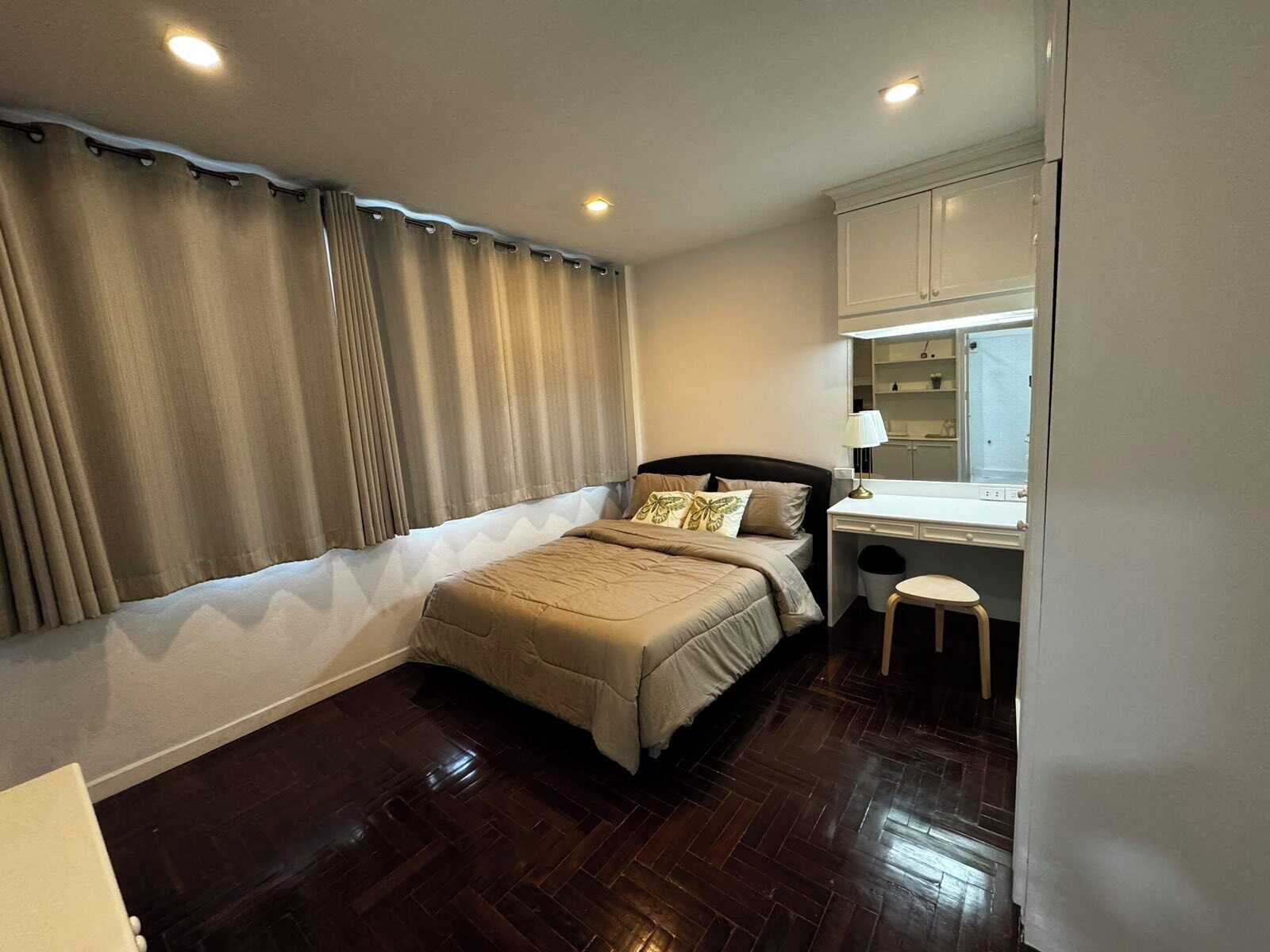 A bedroom with a bed, a desk, and a chair.