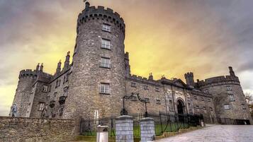A large, historic castle with a prominent central tower, multiple windows, and a grand entrance.
