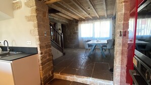 A kitchen with stone walls, a wooden ceiling, and a tiled floor. - Village house (9 pers), ideal for families, in the heart of the Jura mountains (Cesancey)