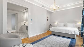 Un dormitorio moderno con una cama grande, una araña y vistas al pasillo.