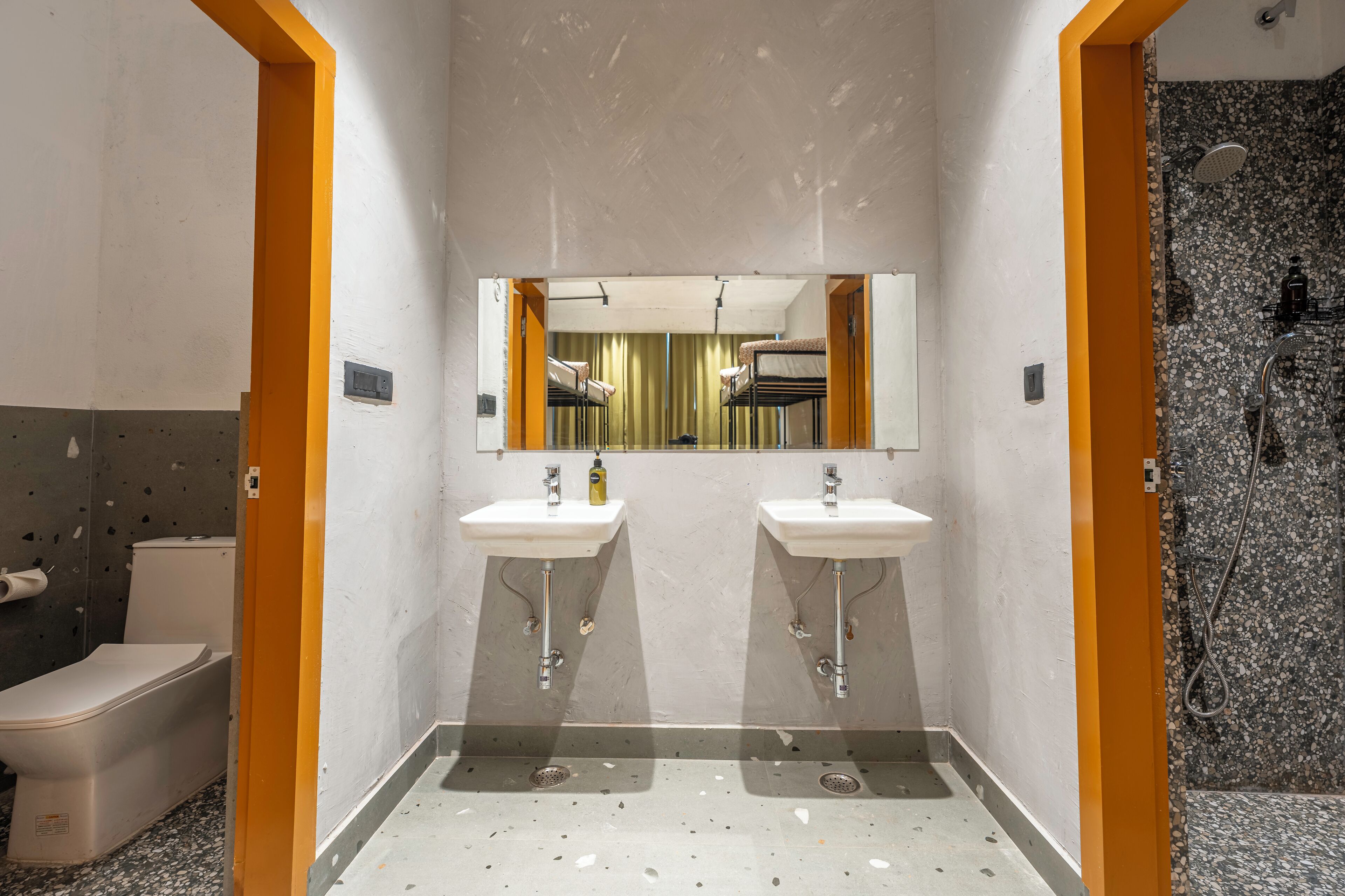 A bathroom with two sinks, a toilet, and a shower area.