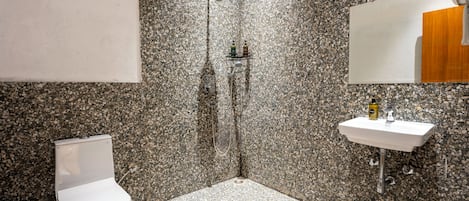 A bathroom with a shower, toilet, and sink.