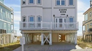 Una casa de dos pisos con balcón, un garaje y un letrero que dice 'CARPE DIEM 1386'.