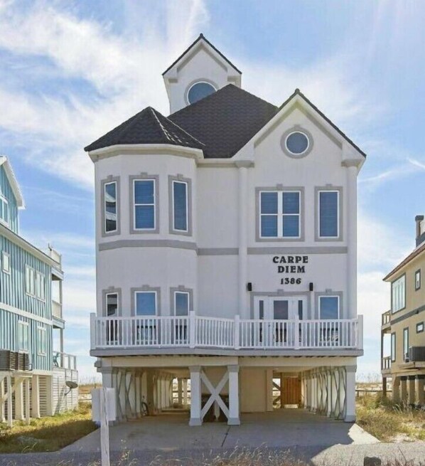 A two-story house with a balcony, a garage, and a sign reading 'CARPE DIEM 1386'.