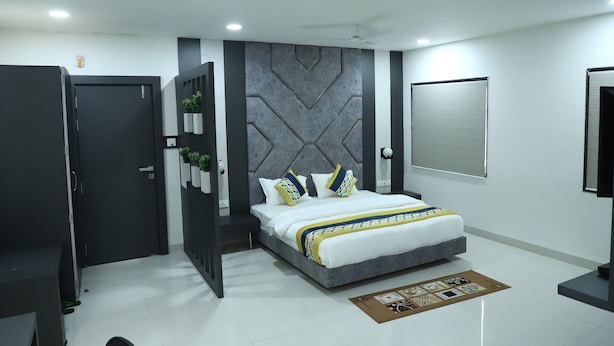 A modern bedroom with a bed, a wardrobe, and a wall-mounted air conditioning unit. - Hotel Singhnature (Khandwa)