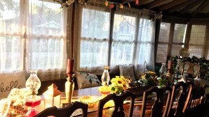 A dining table set with chairs, floral decorations, and a 'hello' pillow. - Historic home 2-bedroom upstairs pet friendly apartment w/ pool in St. Aug  (St. Augustine)