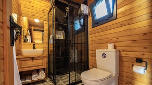 A wooden cabin bathroom with a glass shower enclosure, a sink, and a toilet. - Roseira Bungalov (Milas)