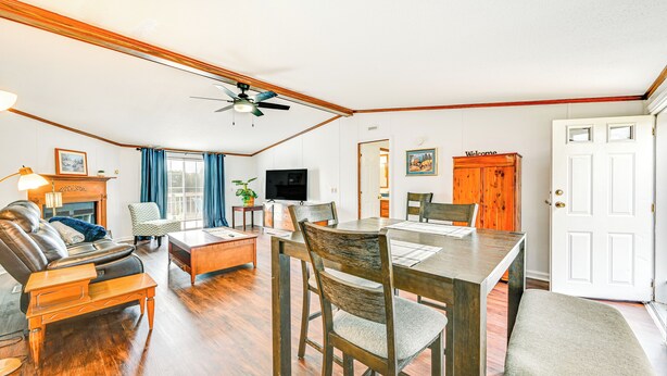 Amplia sala de estar con una mesa de comedor de madera, sofá de cuero y chimenea.