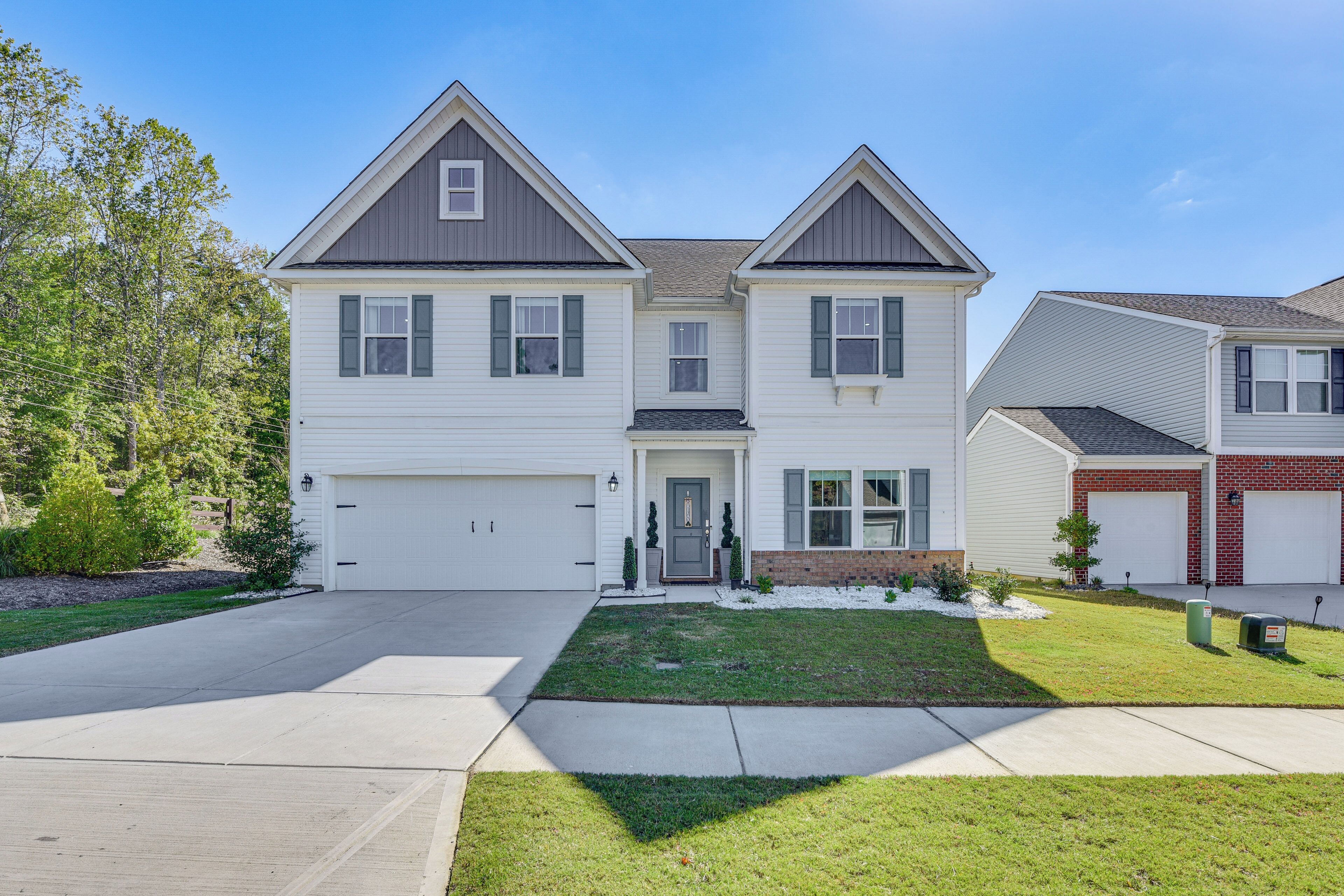 A two-story house with a garage, a front lawn, and a mailbox.