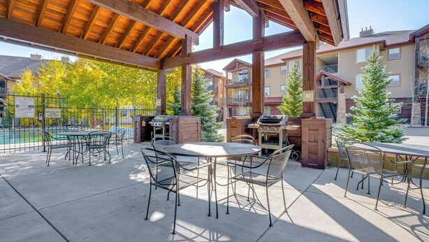 An outdoor patio area with a covered seating area, barbecue grill, and pool. - Downtown WP Condo w/ Pool: Steps to Concert Venue! (Winter Park)