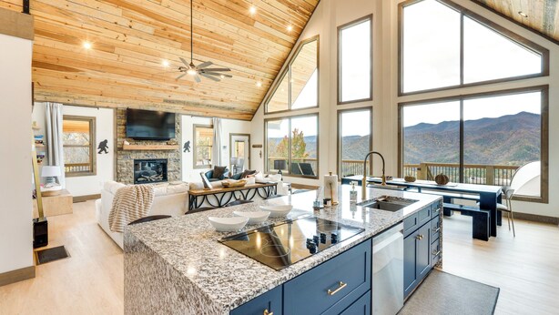 A spacious kitchen with a large island, a dining area, and a living room with a fireplace.