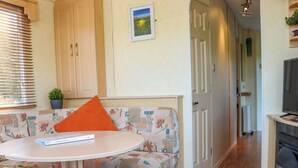 En hyggelig opholdsstue med sofa, et lille bord og et fjernsyn.