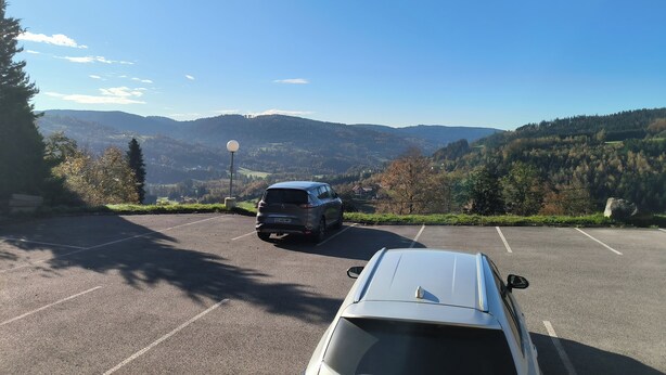 A parking area with a view of a mountainous landscape. - Charming Studio (Le Tholy)