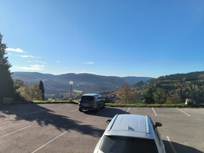 A parking area with a view of a mountainous landscape. - Charming Studio   (Le Tholy)