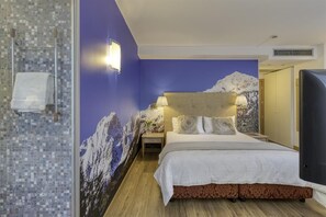 A hotel room with a bed, a nightstand, a wall-mounted lamp, and a bathroom with a shower and a towel rack. - Hotel Sporting Trento (Trento)