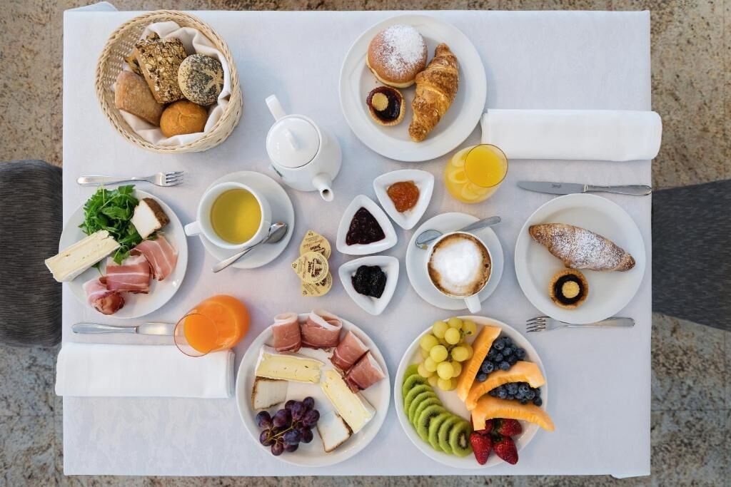 A breakfast spread with various foods and drinks on a table.