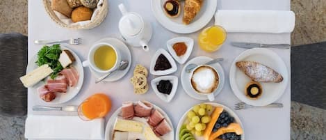 A breakfast spread with various foods and drinks on a table.