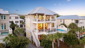 Ein mehrstöckiges Haus mit Balkon, Schwimmbad und einer Treppe, die zu den oberen Stockwerken führt.