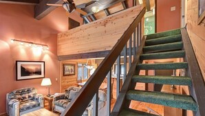 A wooden staircase with a green carpeted handrail leading to an upper level. - Wildflower 62: Nice Condo, Close to the Green Line (Mammoth Lakes)