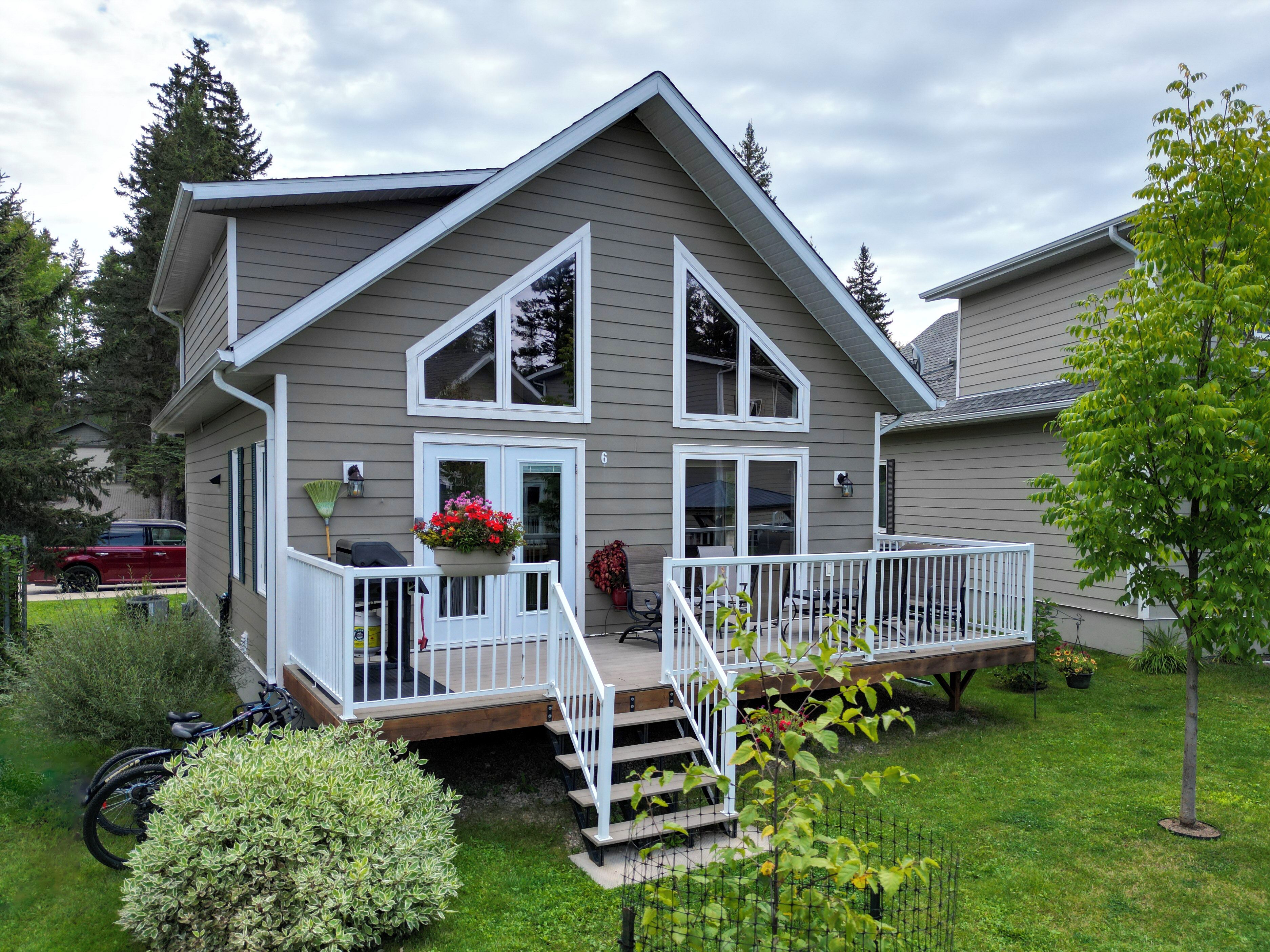 A two-story house with a front porch, a covered patio, and a small deck.