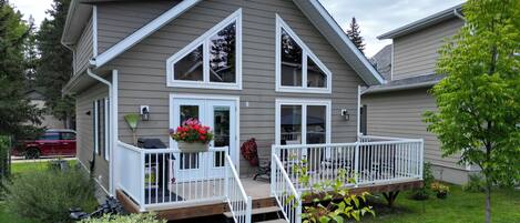 A two-story house with a front porch, a covered patio, and a small deck.