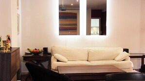 A living room with a beige sofa, a wooden coffee table, and a small side table with a fruit bowl. - Dream Vacation at Casa Vicki (Almeria)