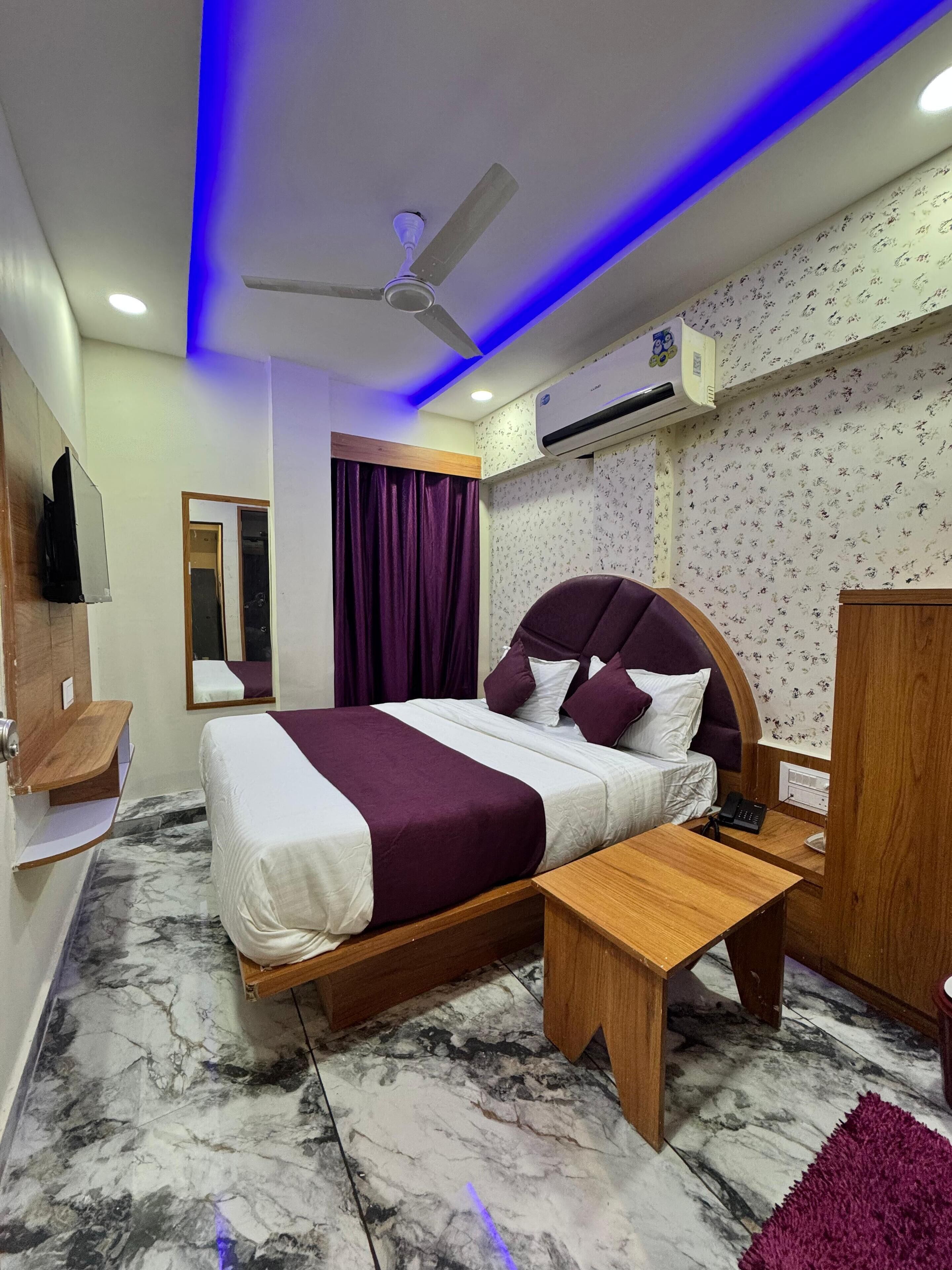 A modern bedroom with a bed, bedside table, and a ceiling fan.