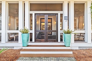 Stunning building entrance with a dark door, potted plants, and a sign reading 295.