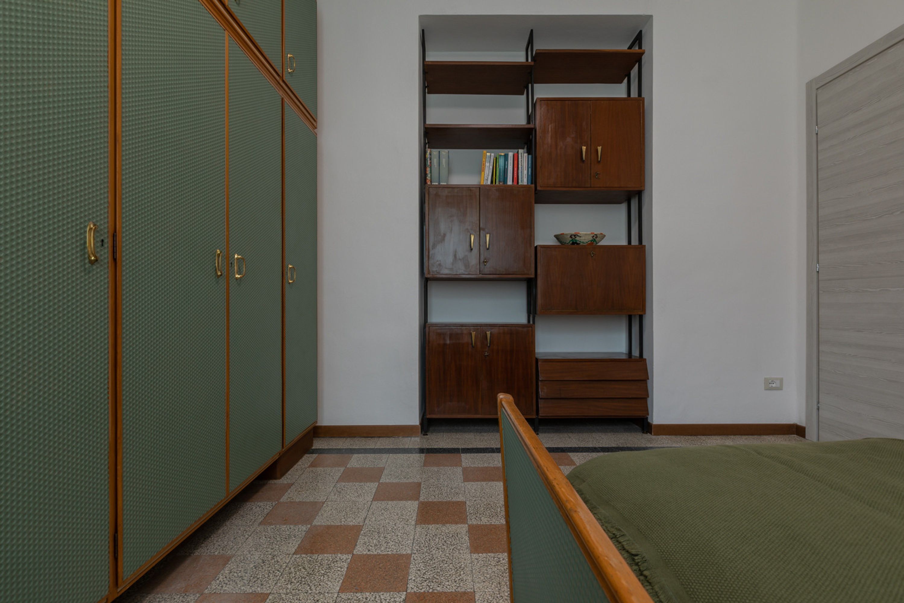 Une chambre à coucher comprenant un lit, une armoire et une bibliothèque intégrée.