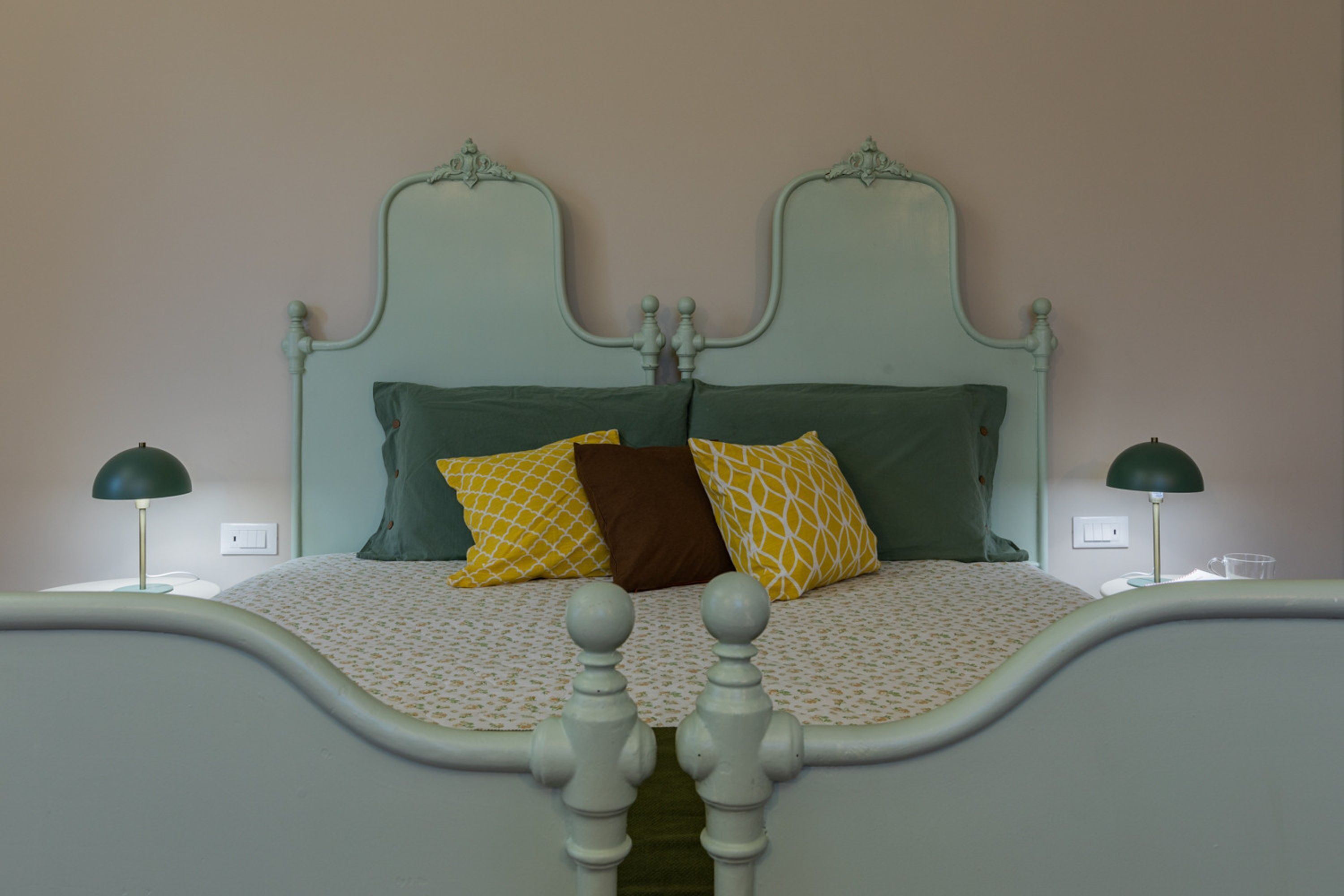 A bed with a white headboard and a patterned bedspread.